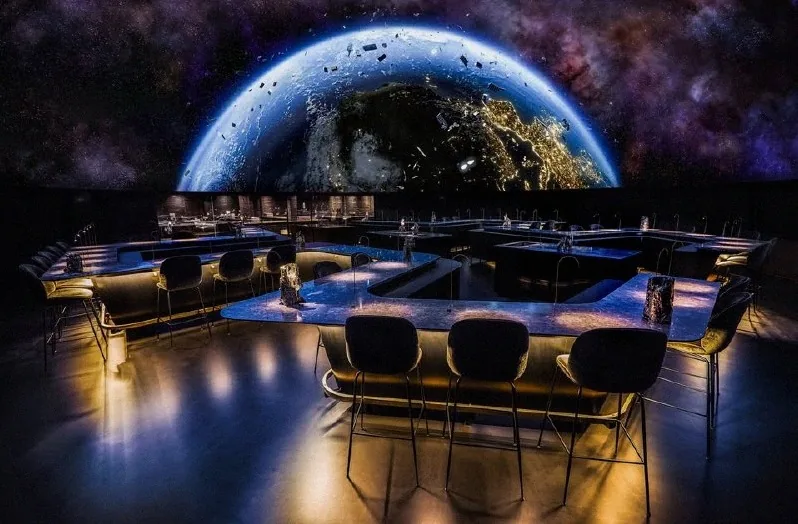The dome projecting a view of Earth from orbit over the dining tables